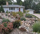 Front yard rock garden with boulders, river rock, and drought-tolerant plants